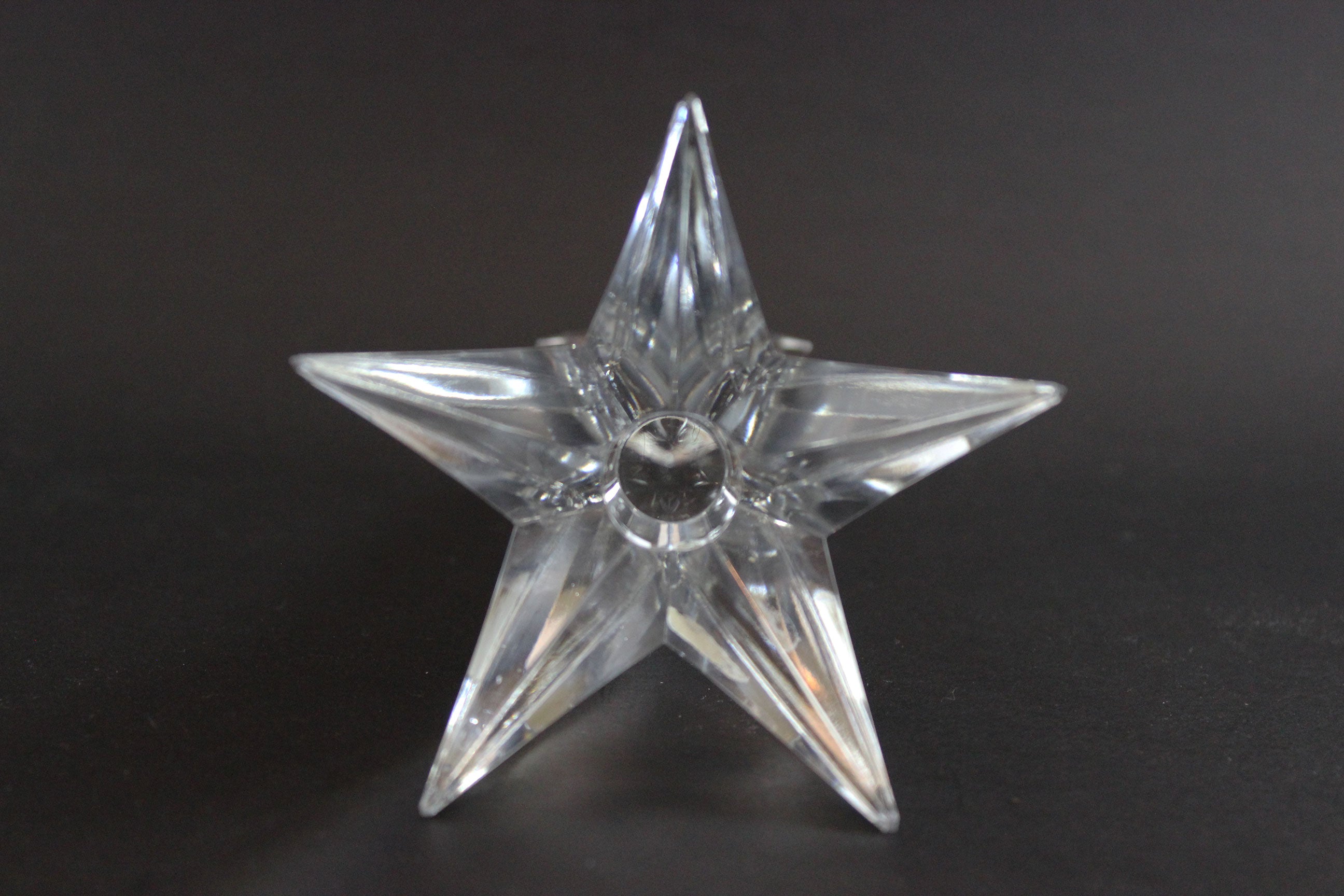 Set of crystal star-shaped candleholders on a dark background