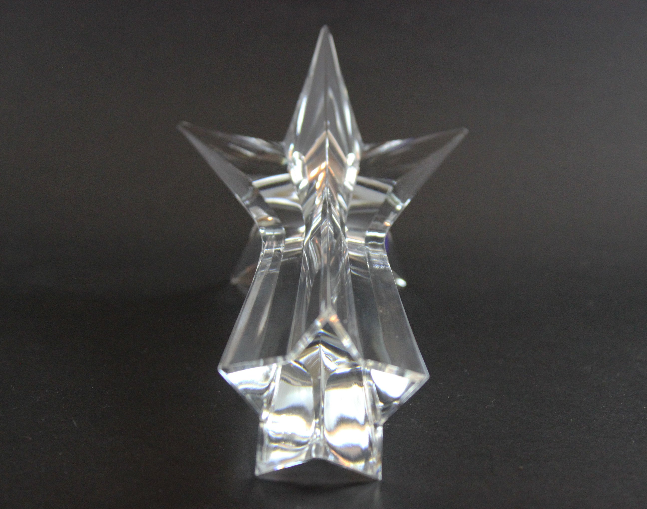 Set of crystal star-shaped candleholders on a dark background