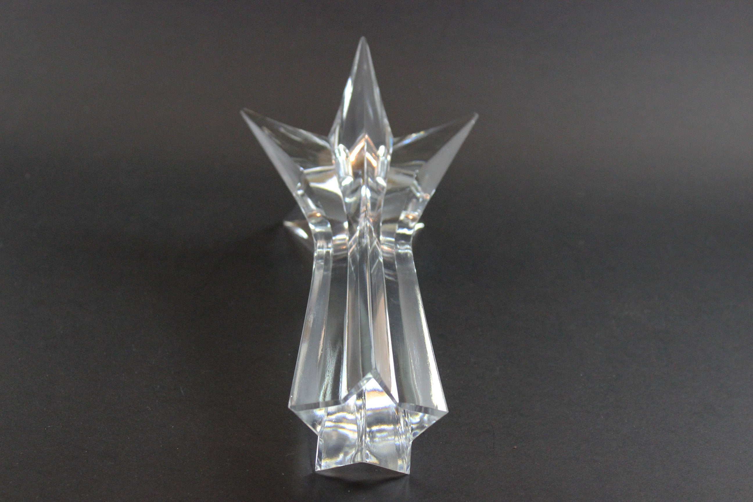 Set of crystal star-shaped candleholders on a dark background