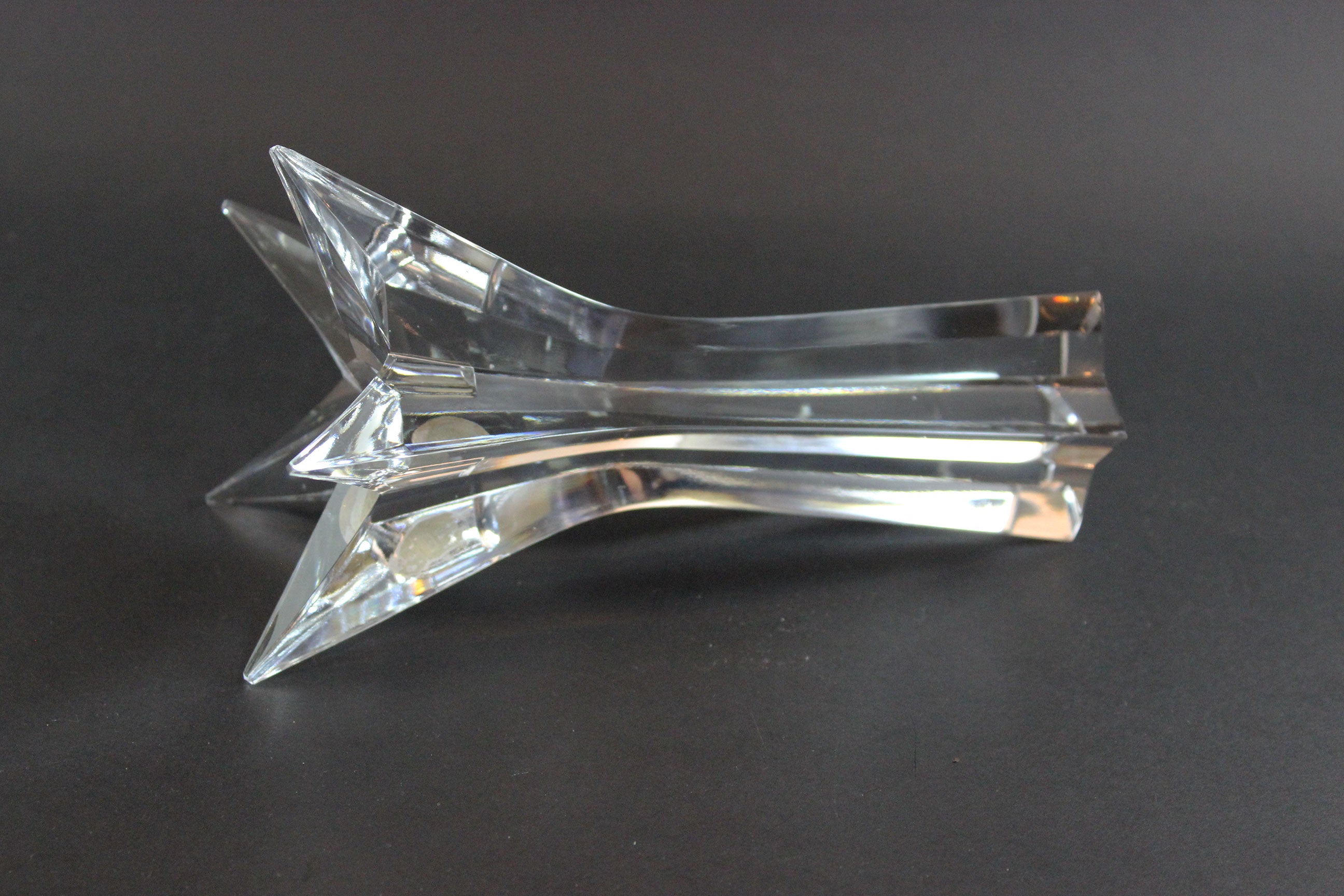Set of crystal star-shaped candleholders on a dark background