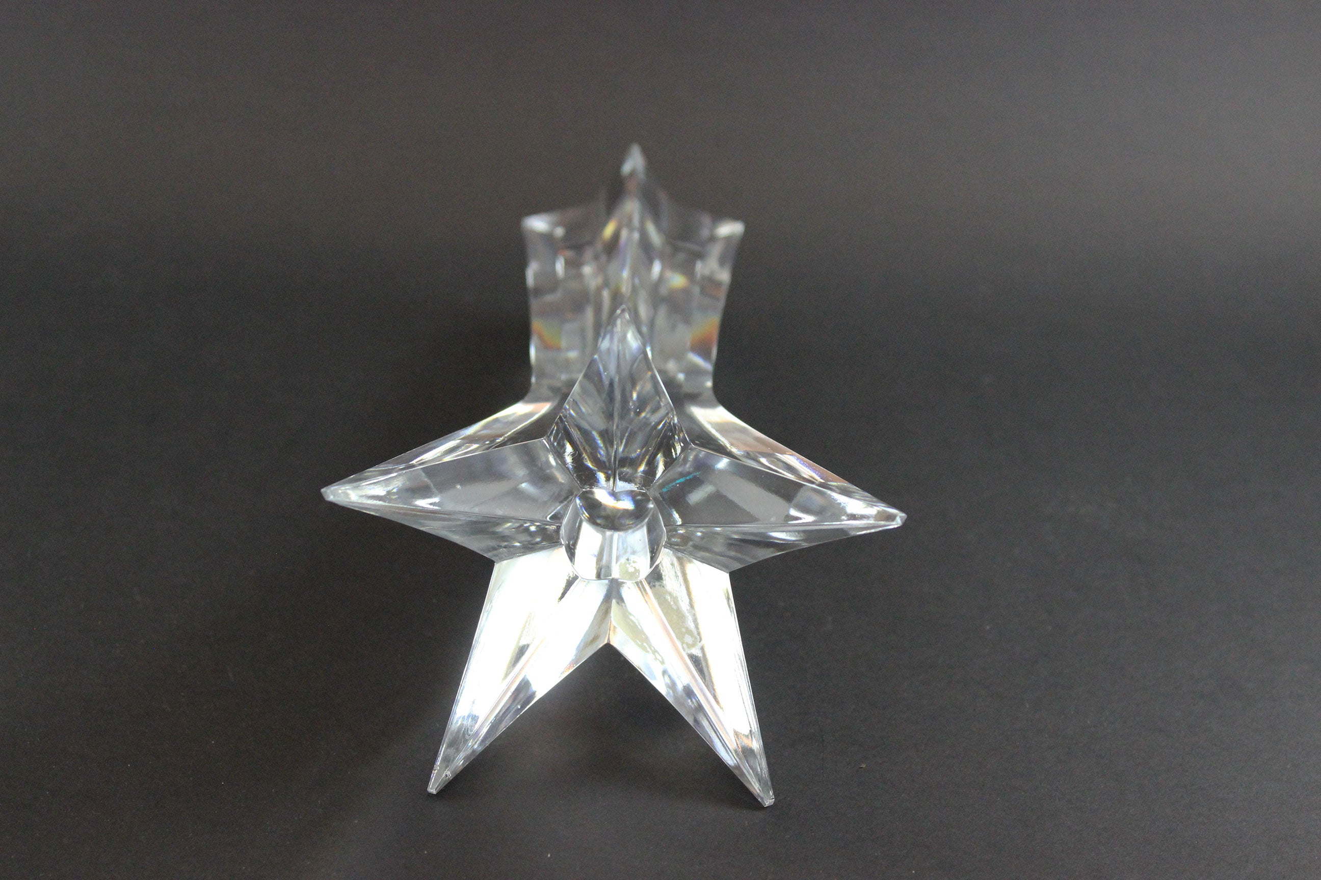 Set of crystal star-shaped candleholders on a dark background