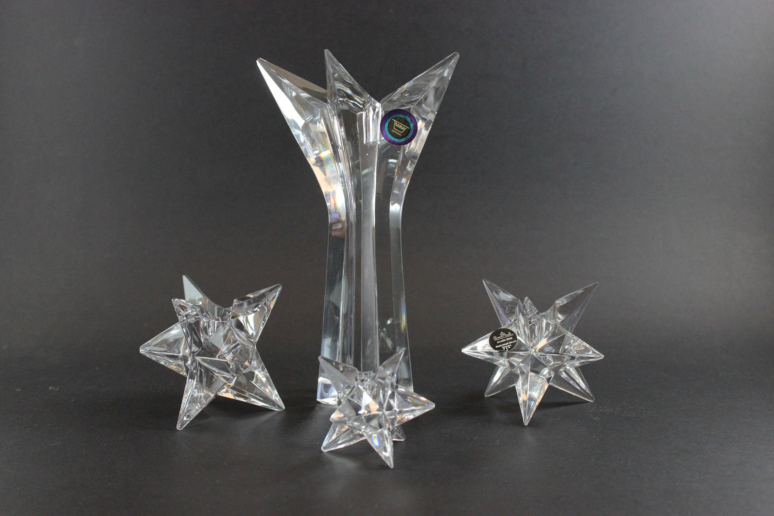 Set of crystal star-shaped candleholders on a dark background