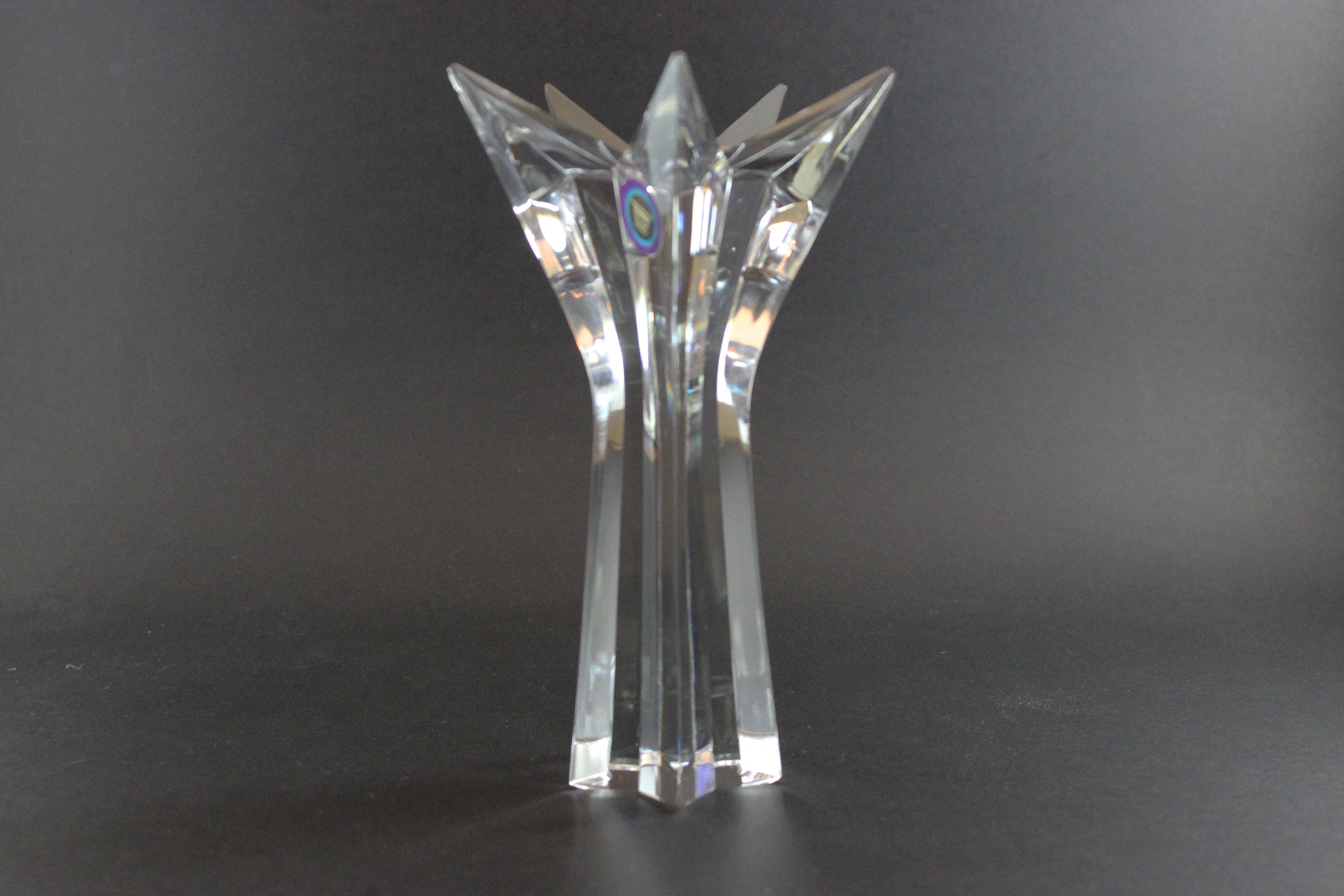 Set of crystal star-shaped candleholders on a dark background