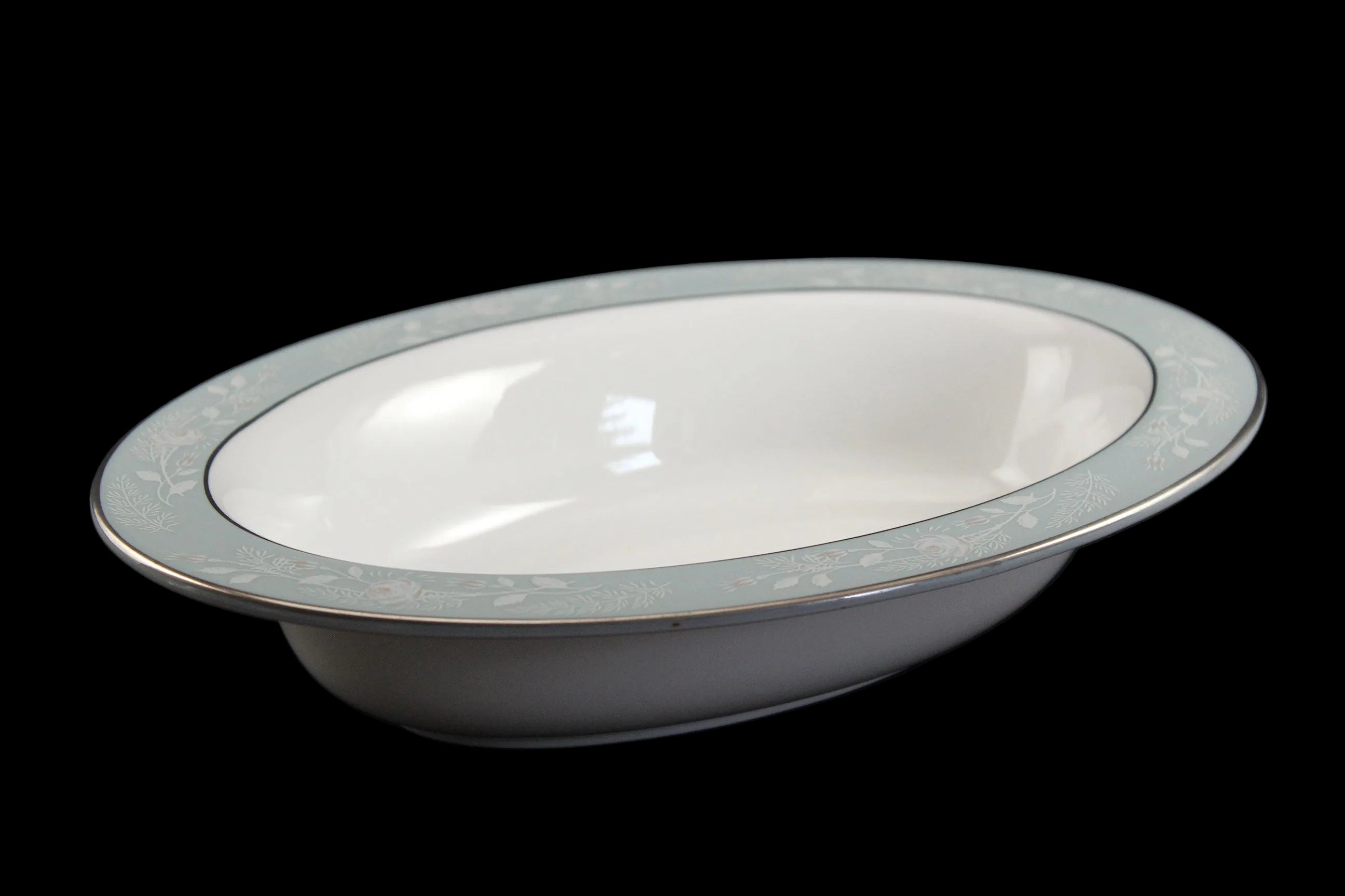 Royal Worcester Bridal Rose oval bowl with blue grey band and silver rims on a black background