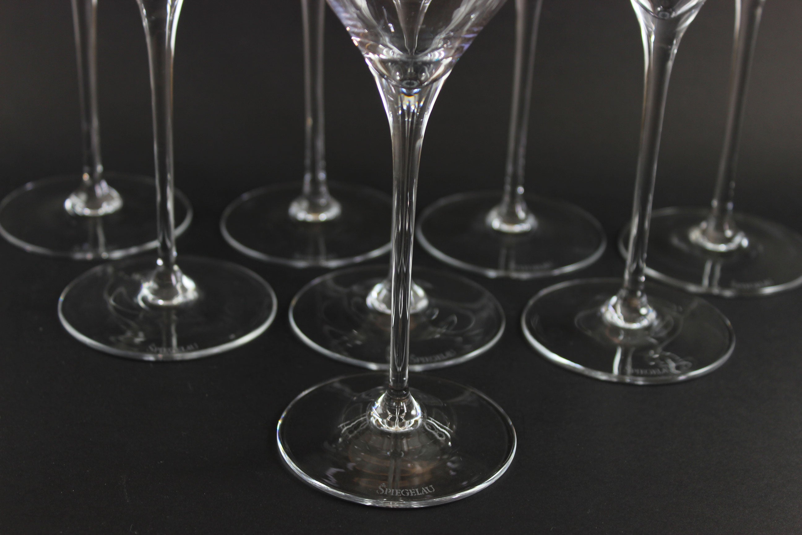 Set of clear glass wine glasses on a black background