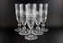 Set of six crystal glasses with diamond cut pattern on a black background