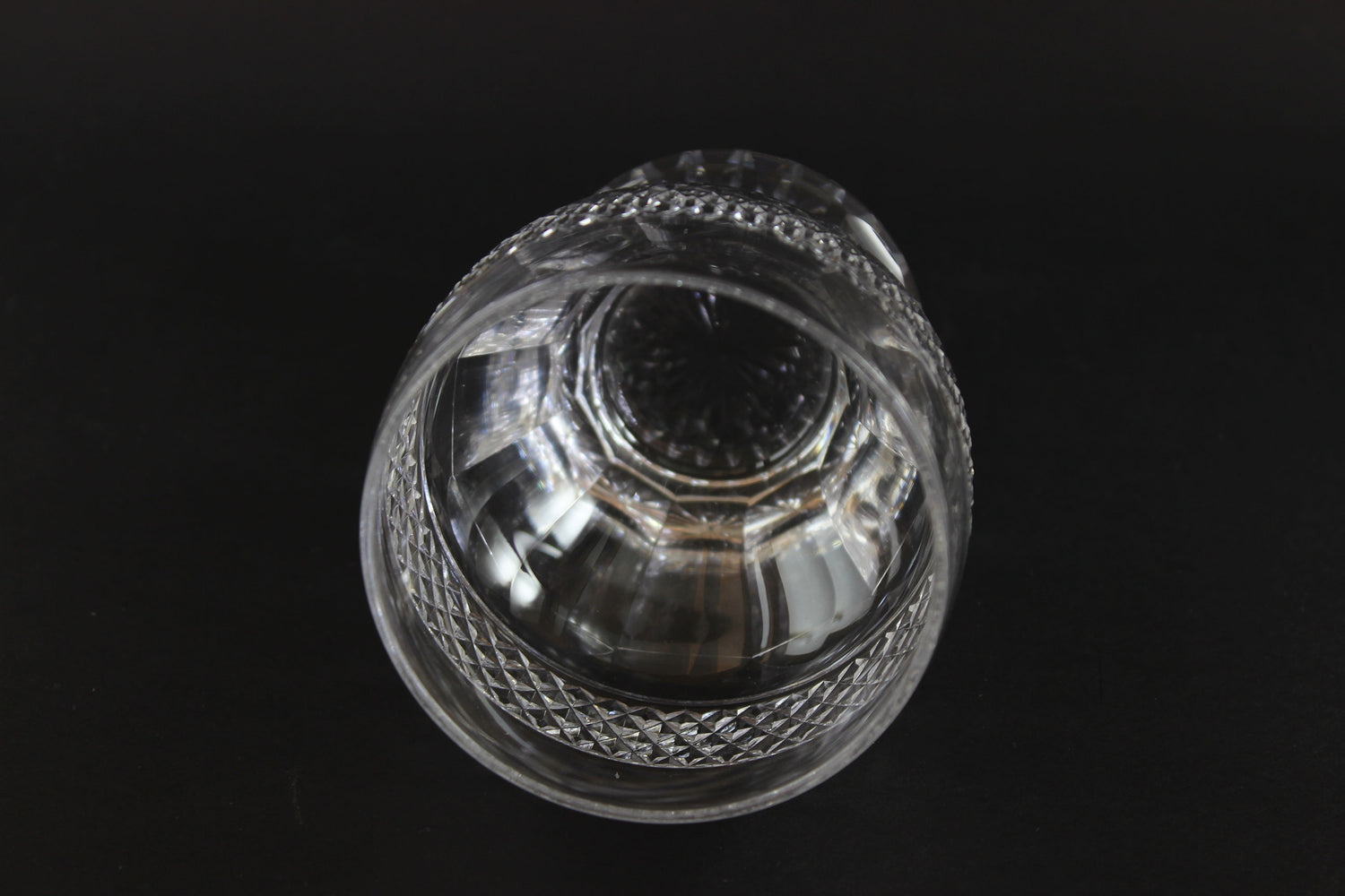 Clear crystal tumblers with textured design on a black background