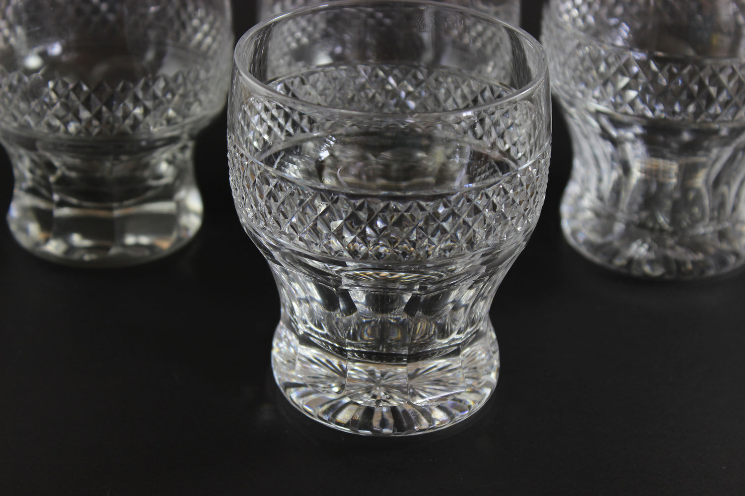 Set of crystal glasses with intricate patterns on a black background