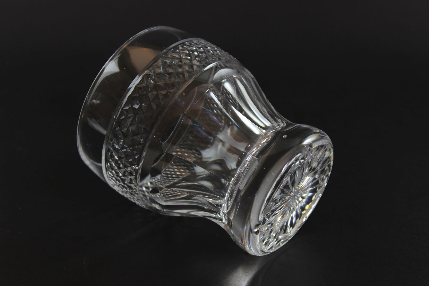 Clear glass knob with textured design on a black background