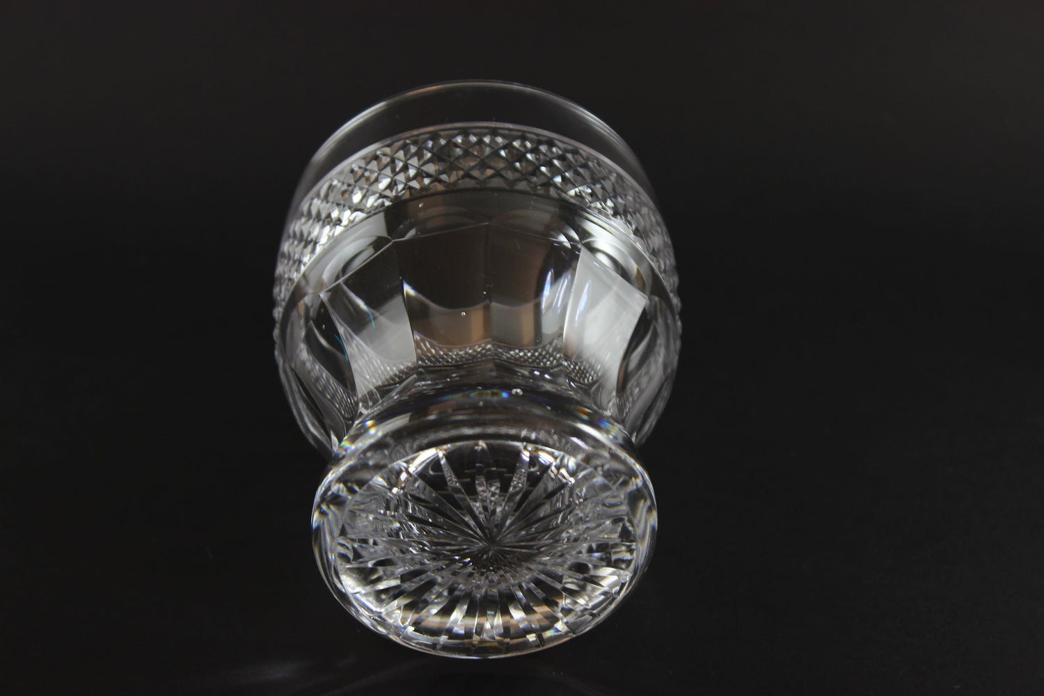 Clear crystal whiskey tumbler with intricate design on a black background