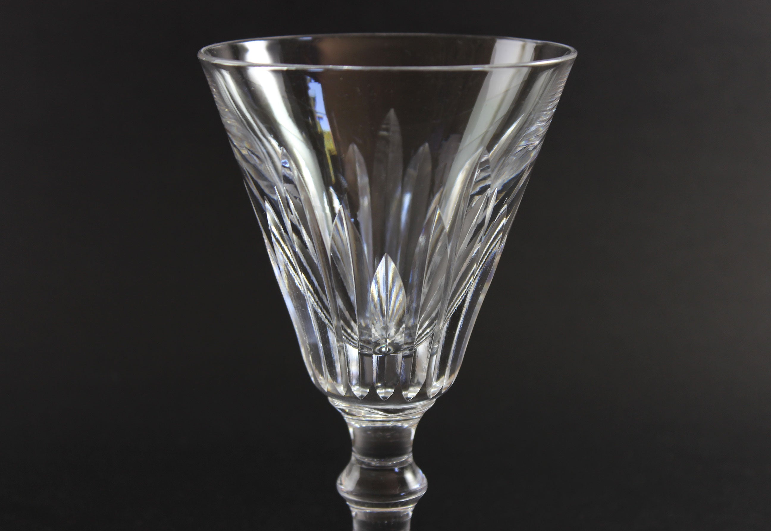 Cut crystal goblet with intricate designs on a black background