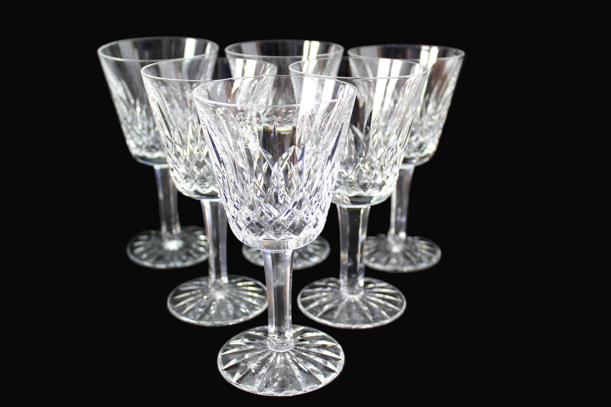 Set of six crystal wine glasses on a dark background