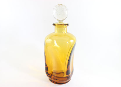 Set of amber pinched glass decanter and six glasses on a white background