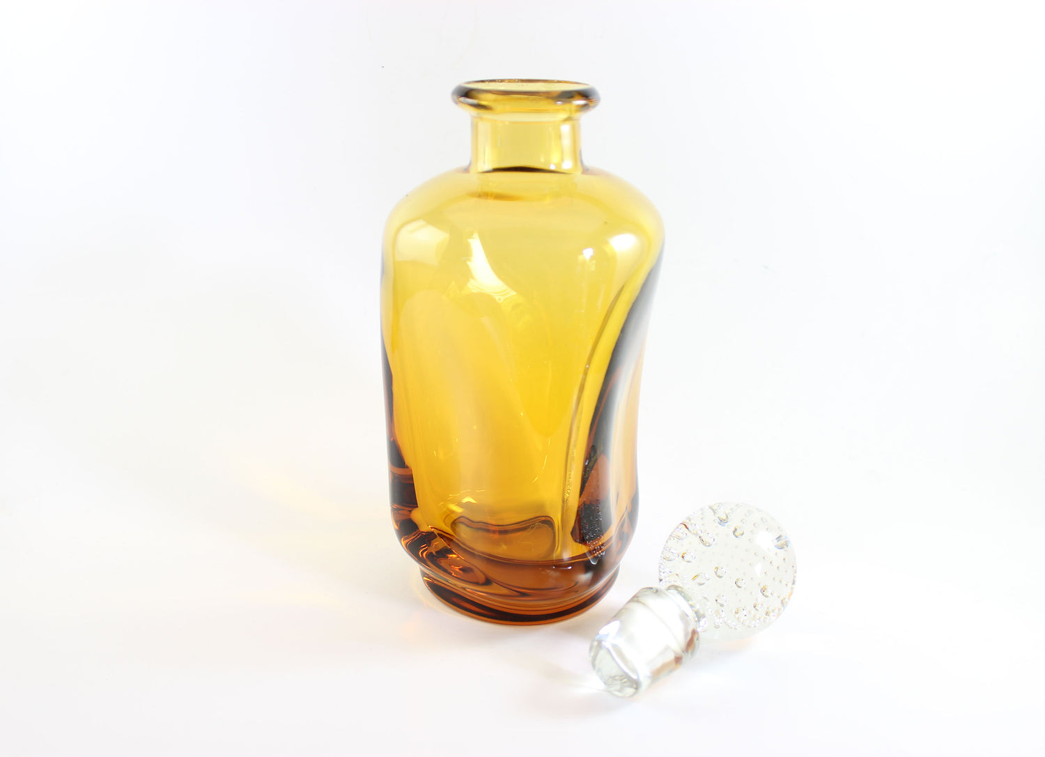 Set of amber pinched glass decanter and six glasses on a white background