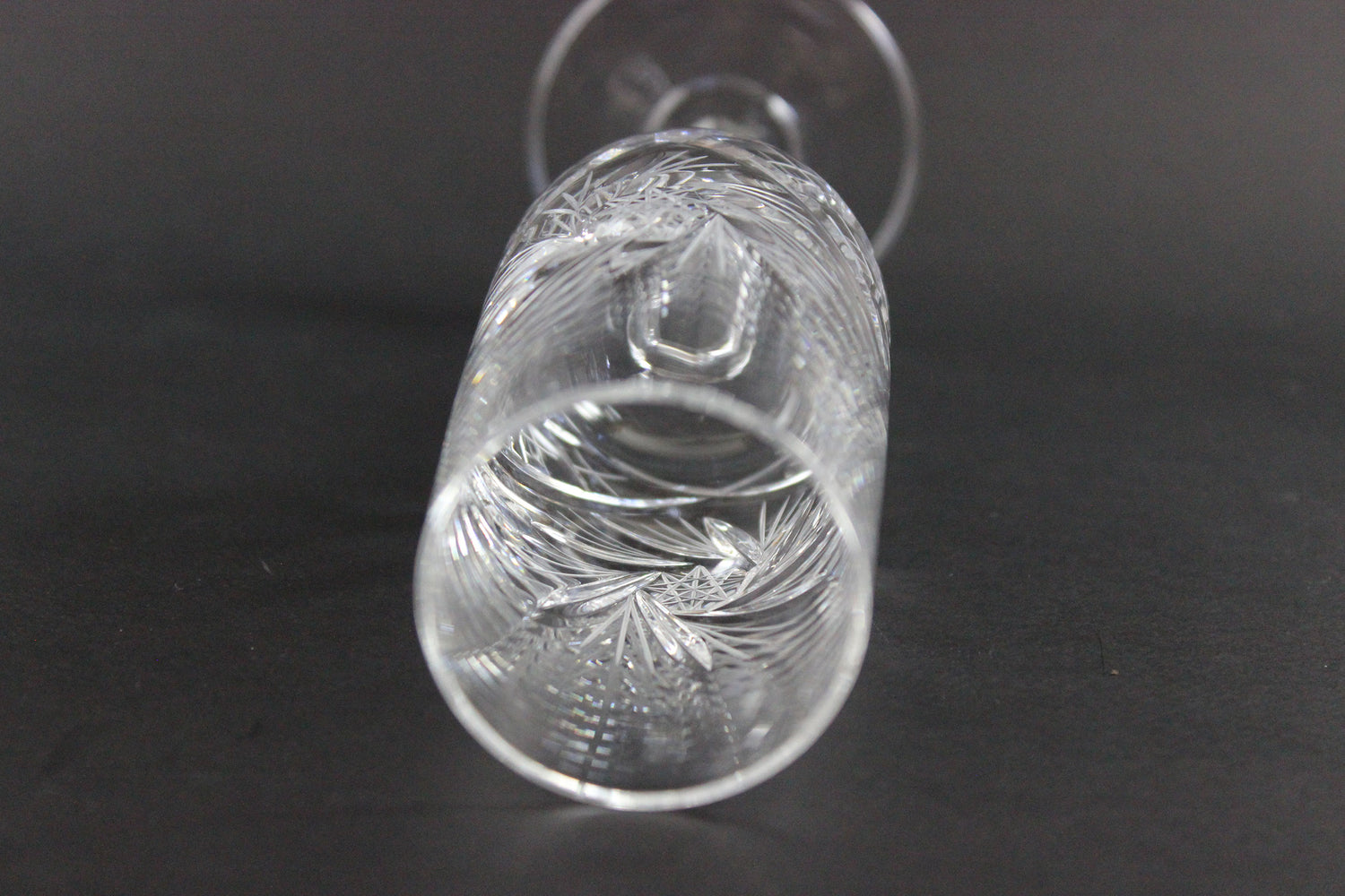 Crystal champagne flute with cut pinwheel design on a black background