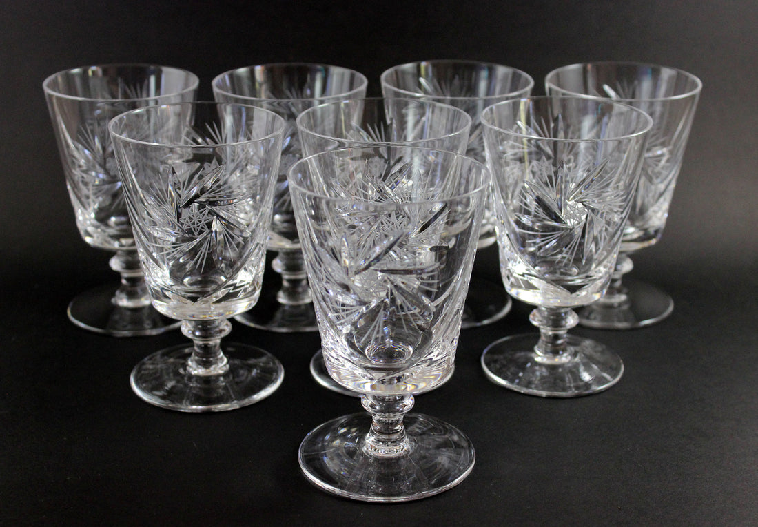 Set of crystal glasses with engraved designs on a black background
