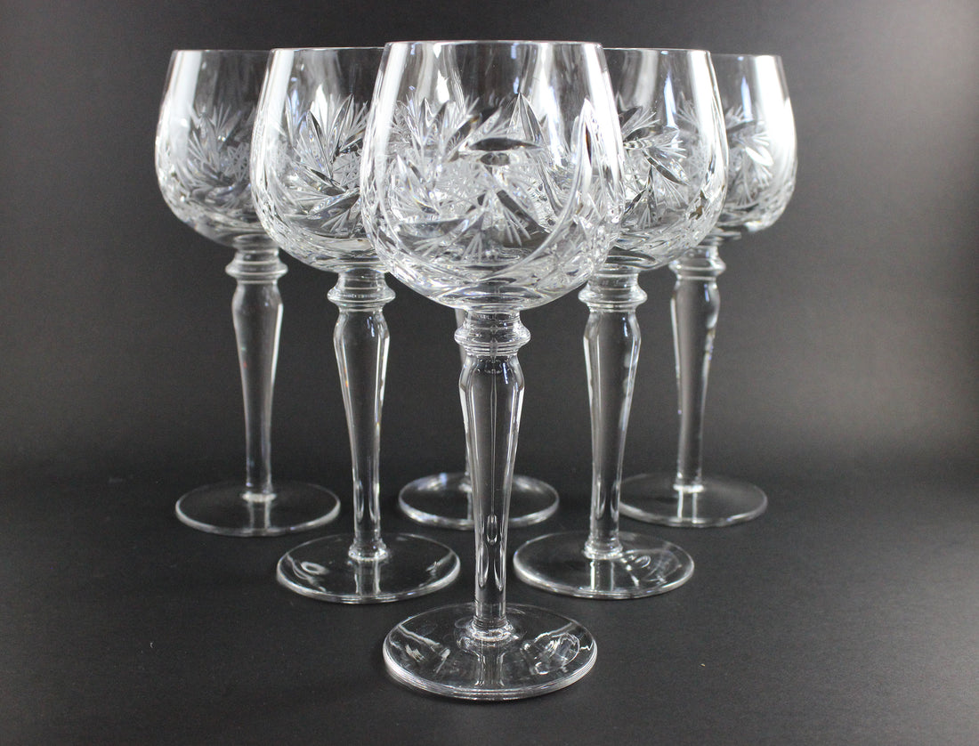 Set of six crystal wine glasses on a dark background