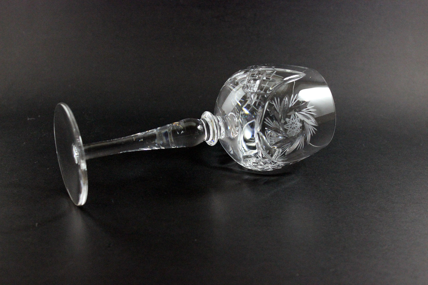 Crystal wine goblet with cut design on a black background