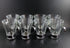 Set of clear glass tumblers with metal bases on a black background