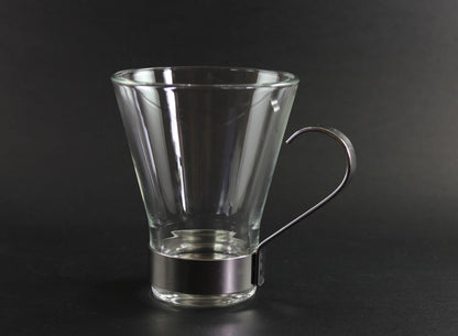 Clear glass mug with metal handle on a black background