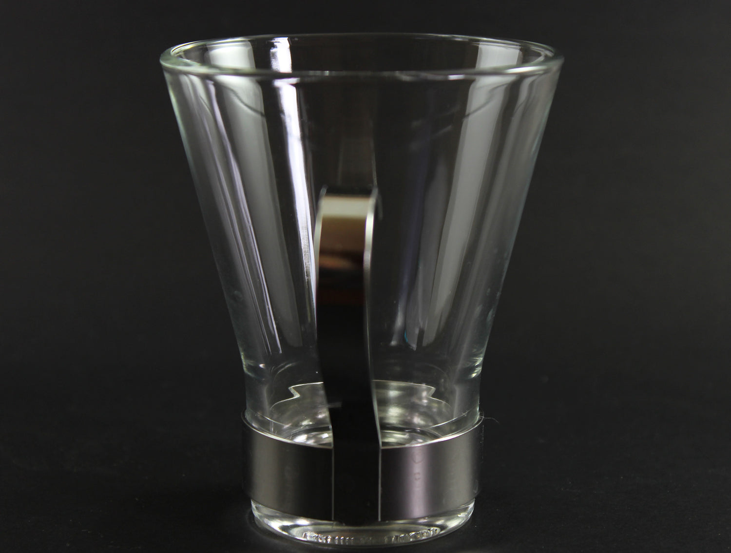 Clear glass mug with metal handle on a black background