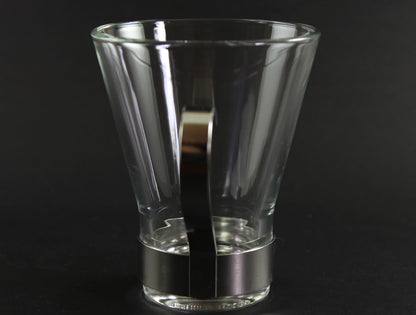Clear glass mug with metal handle on a black background