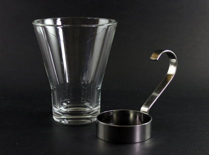 Clear glass mug with metal handle on a black background