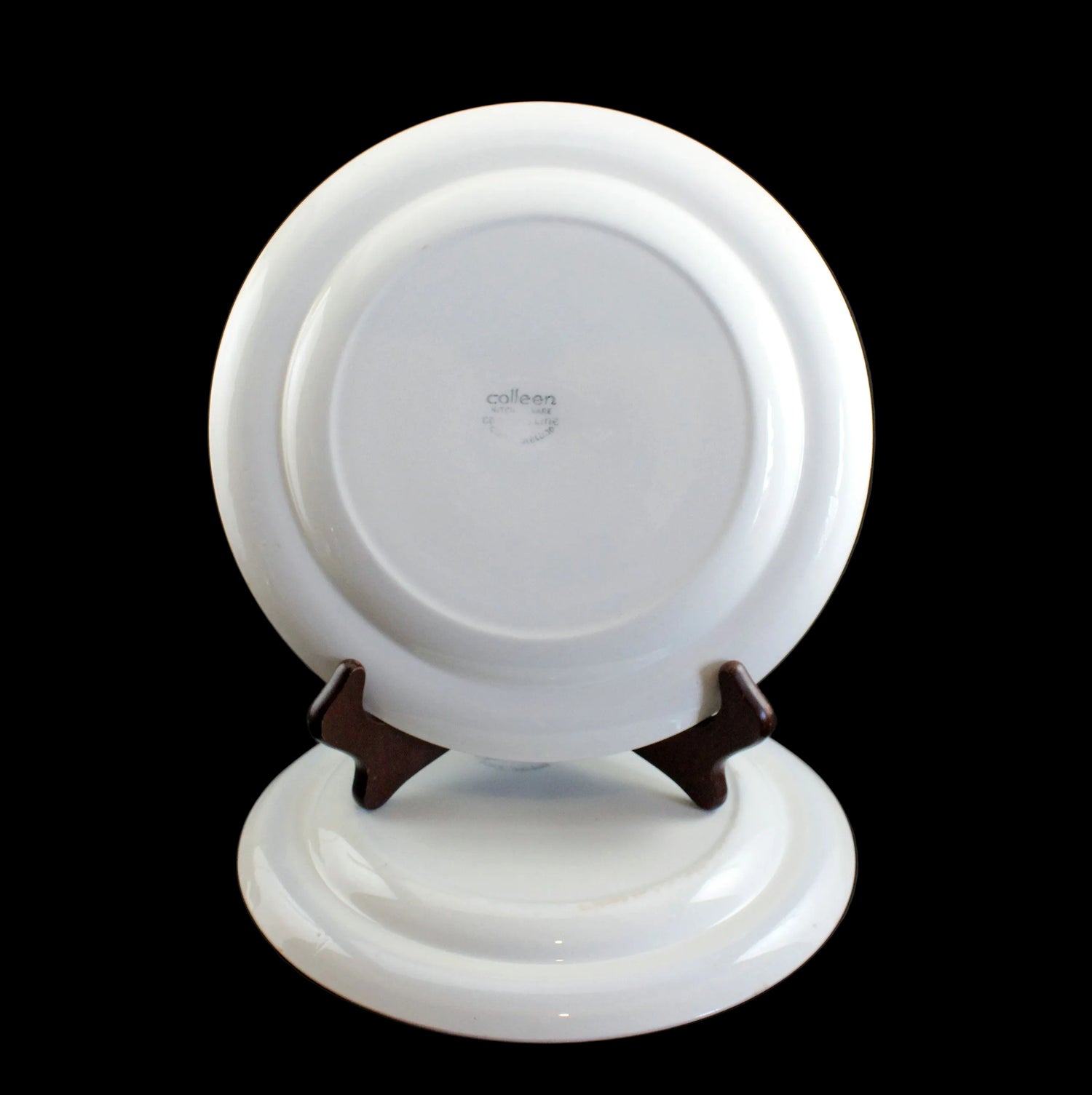 White ceramic plate on a stand with a black background
