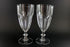 Two clear crystal goblets on a black background