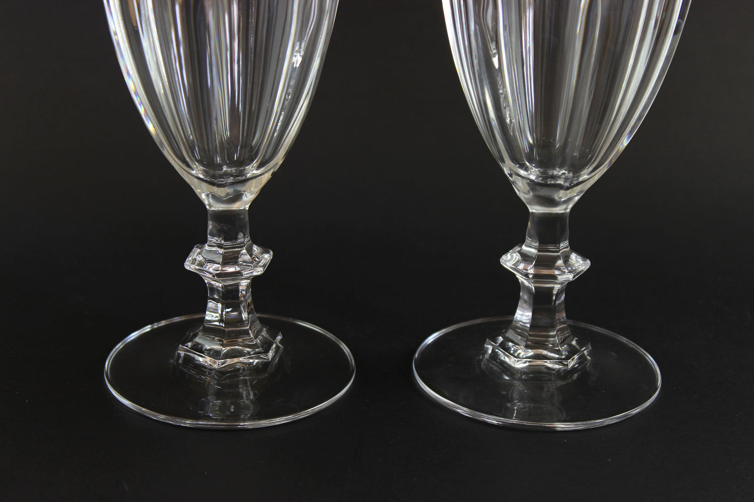 Two clear crystal goblets on a black background