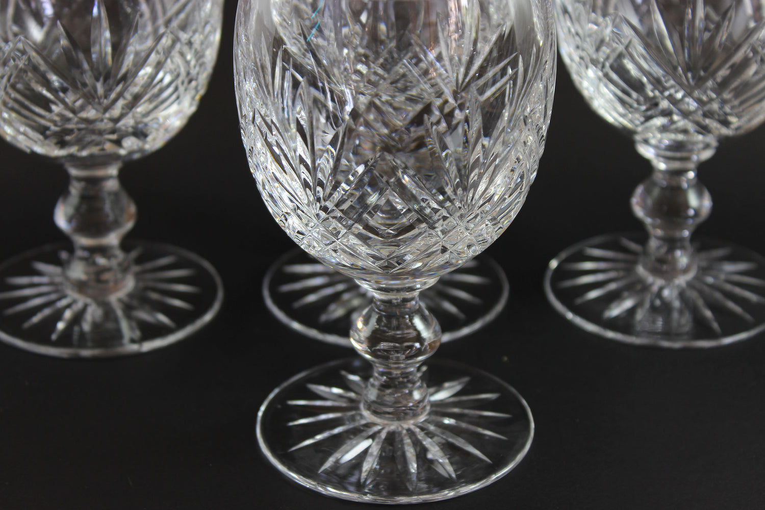 Set of crystal glasses with intricate designs on a black background