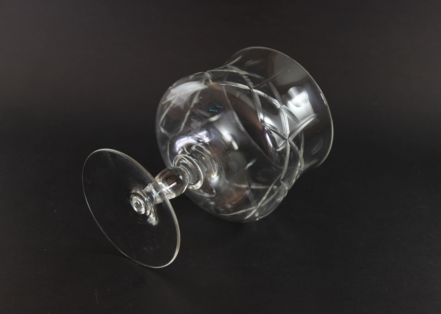Clear crystal goblet with cross and olive cut pattern on a dark background