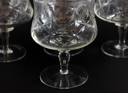 Set of crystal glasses with intricate cut patterns on a black background