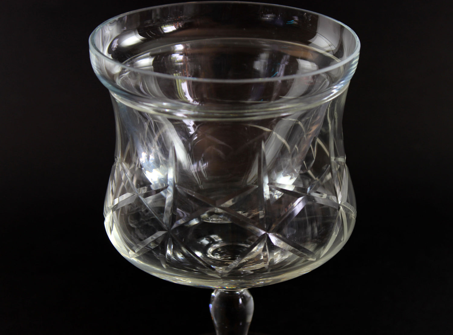 Set of clear glass tumblers with cross and olive cut pattern on a dark background