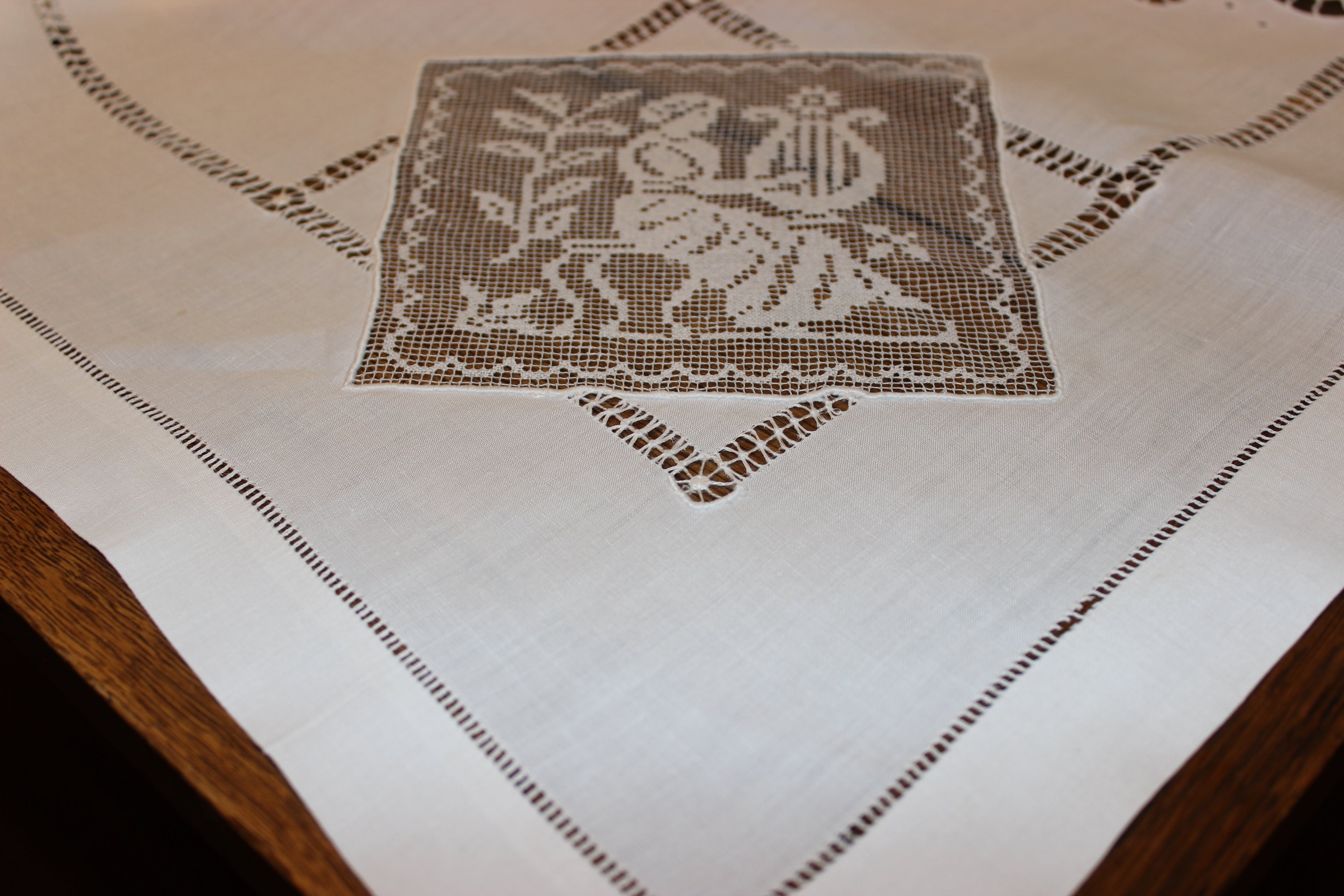 Embroidered tablecloth with a decorative pattern on a wooden surface
