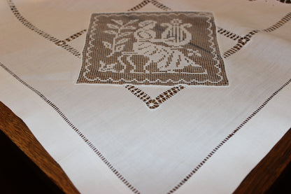 Embroidered tablecloth with a decorative pattern on a wooden surface