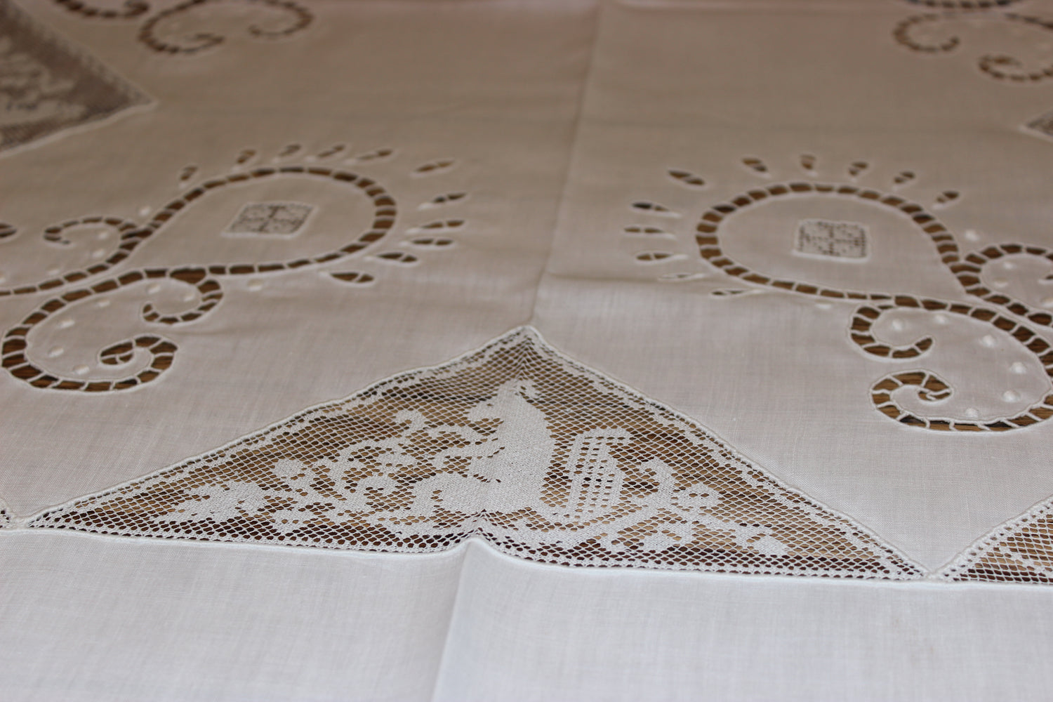 Decorative tablecloth with lace detailing and geometric patterns on a beige background