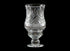 Clear glass hurricane lamp with intricate design on a black background