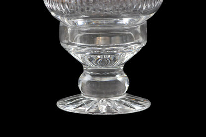 Clear glass hurricane lamp with intricate cut patterns on a black 