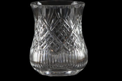 Clear glass candle holder with intricate patterns on a black background