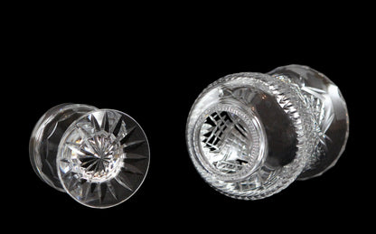 Clear glass hurricane lamp with intricate cut patterns on a black 