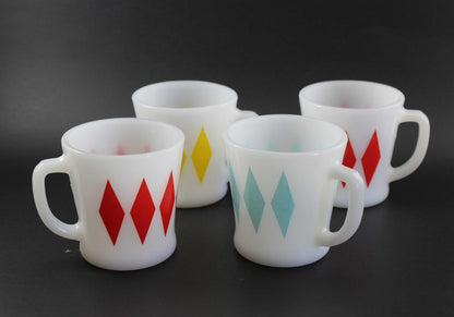 Set of four (4) white glass coffee mugs with a red, yellow, teal and red harlequin diamond pattern, set against a dark gray background.