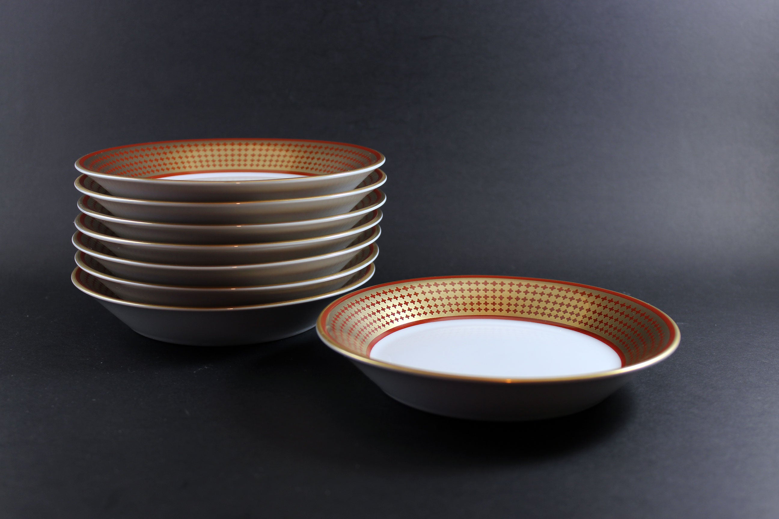 Set of ceramic bowls with decorative rim on a dark background
