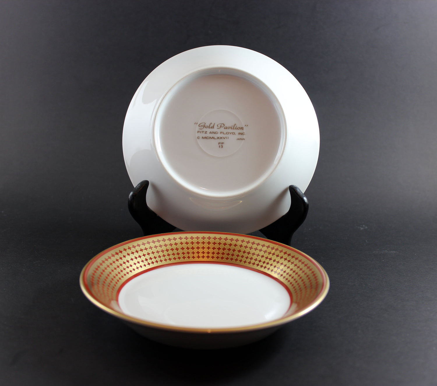 White ceramic bowl with gold rim on a black background