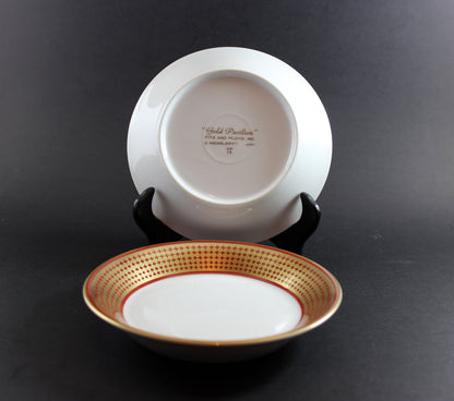 White ceramic bowl with gold rim on a black background