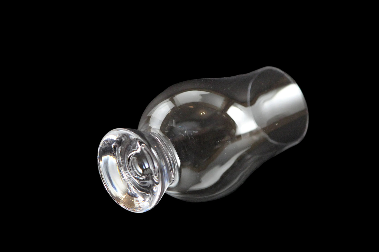 Four clear glass whisky glasses on a black background