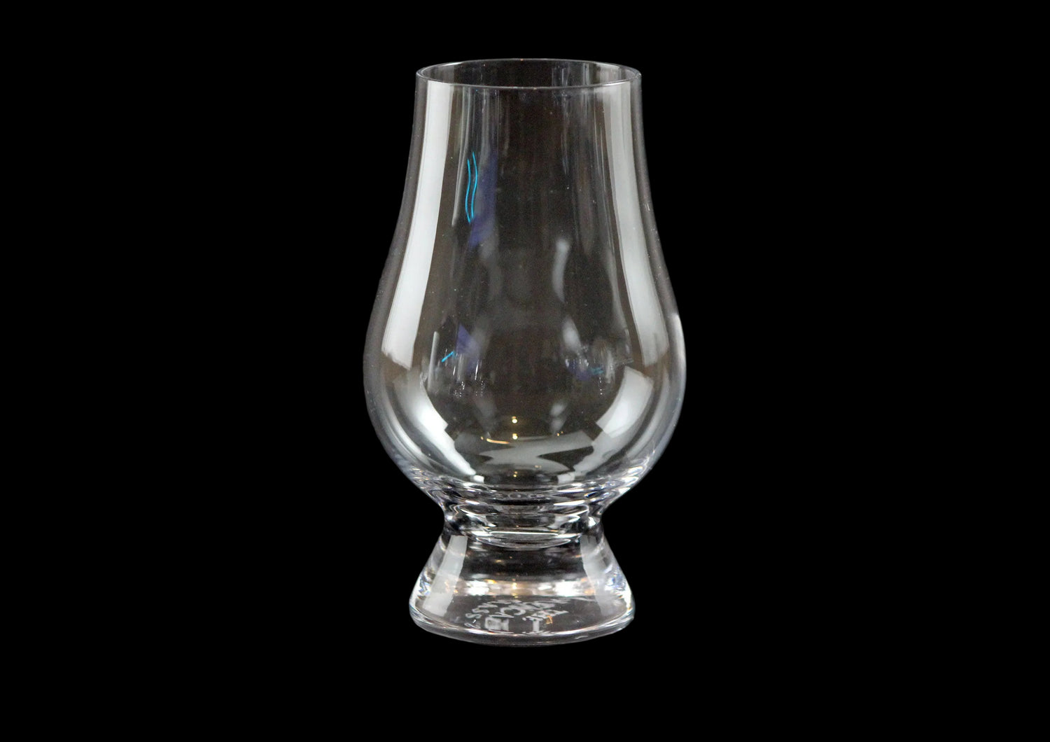 Clear glass whisky glass on a black background