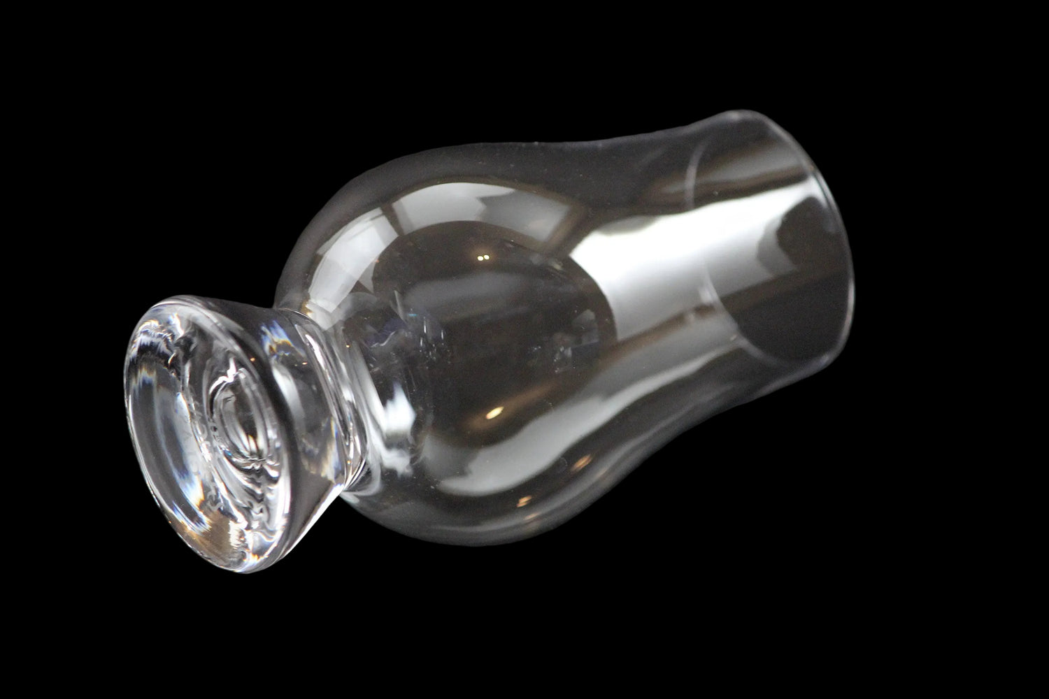 Clear glass whiskey glass on a black background