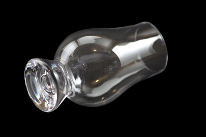 Clear glass whiskey glass on a black background