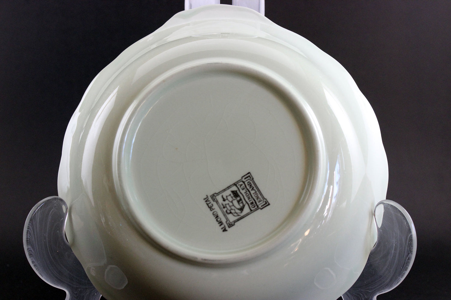 Light green ceramic dish with a visible brand logo on a black background